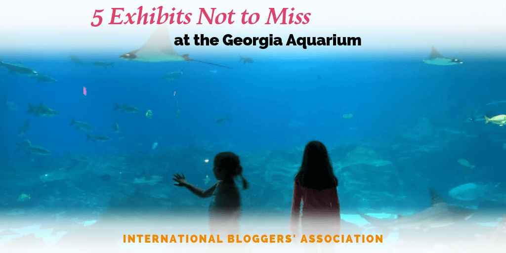 girls standing in front of aquarium window with text overlay "5 Exhibits Not to Miss at the Georgia Aquarium."
